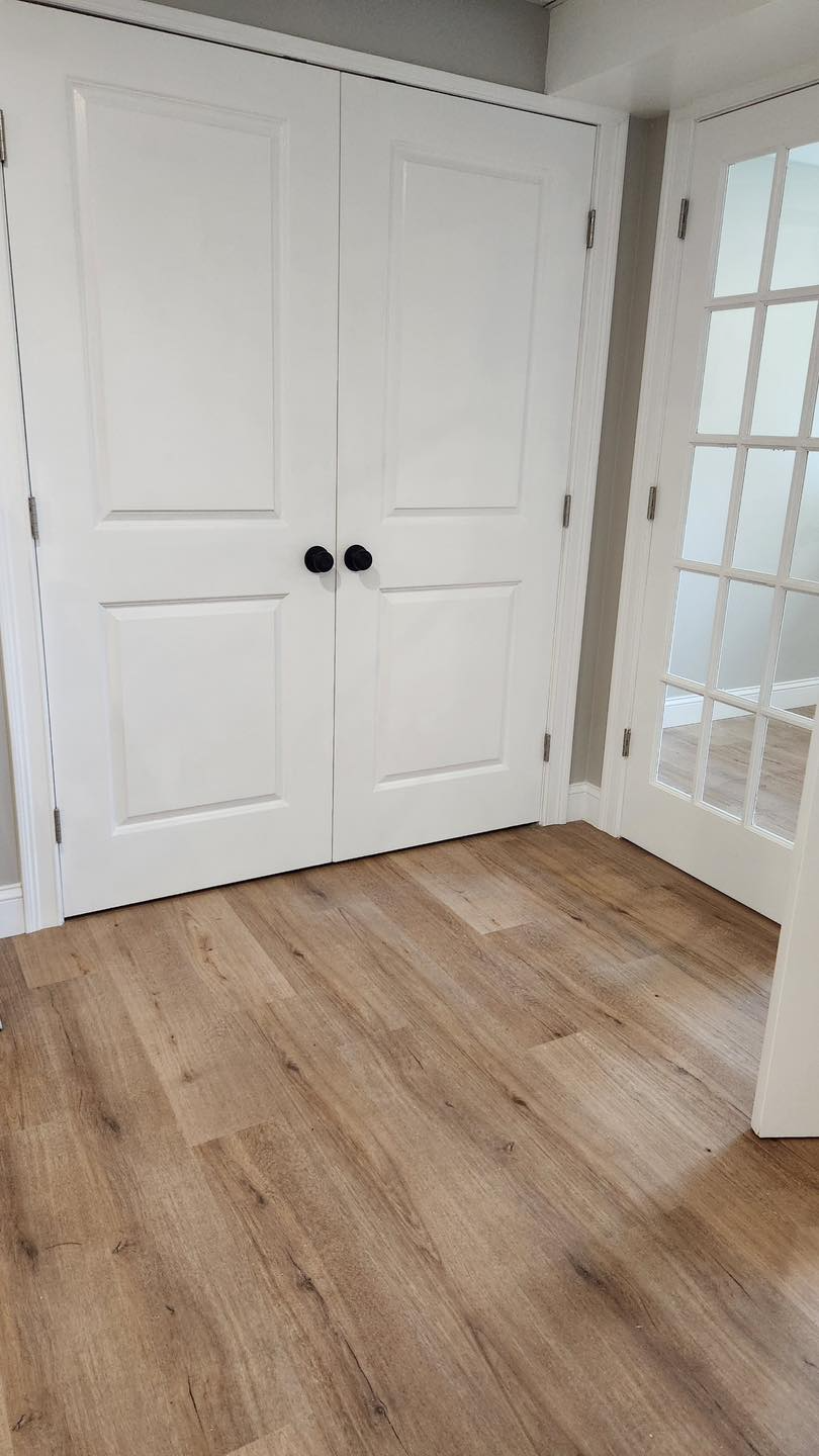 A room with hardwood floors and white doors.