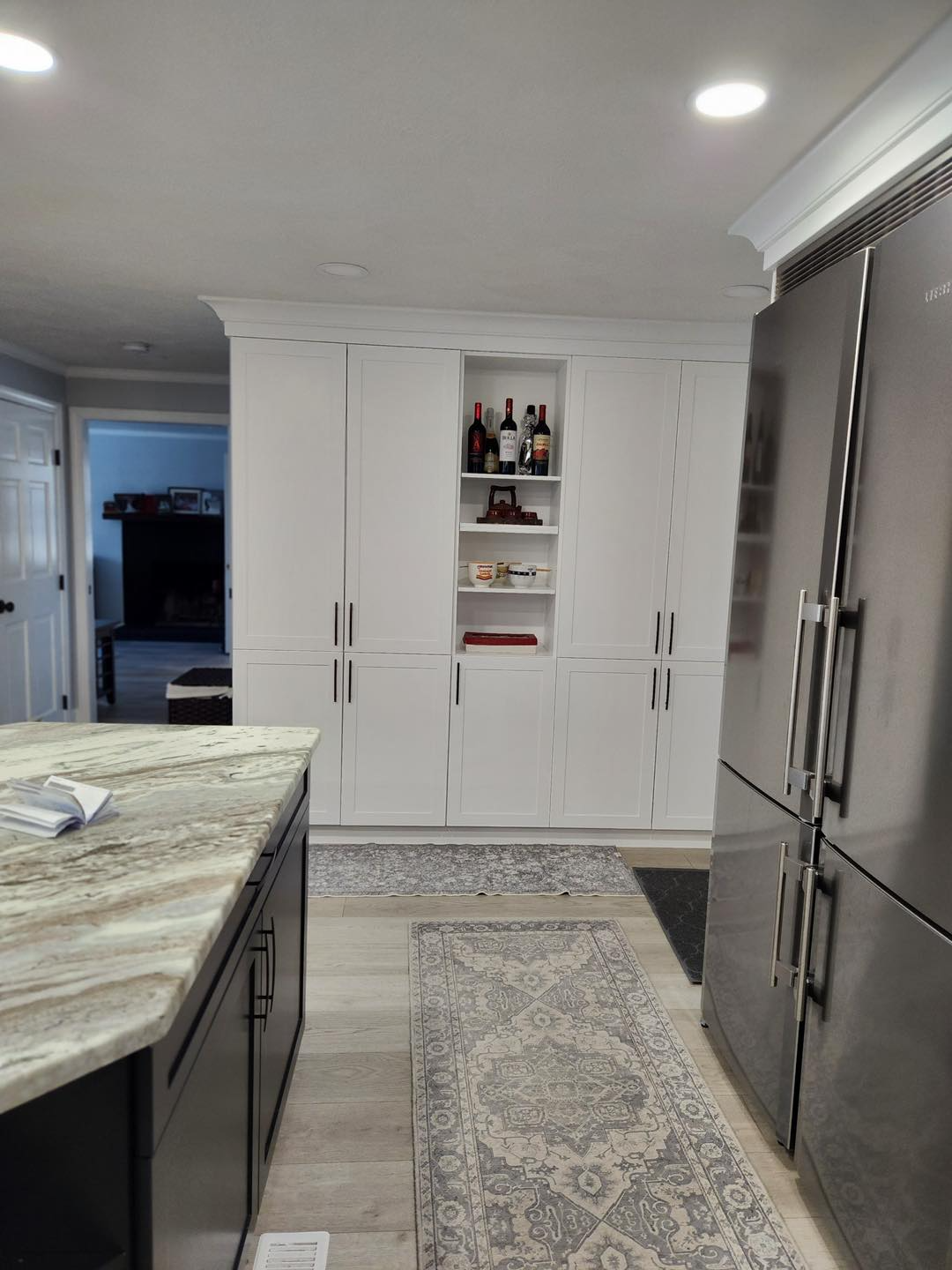 A kitchen with stainless steel appliances and white cabinets.