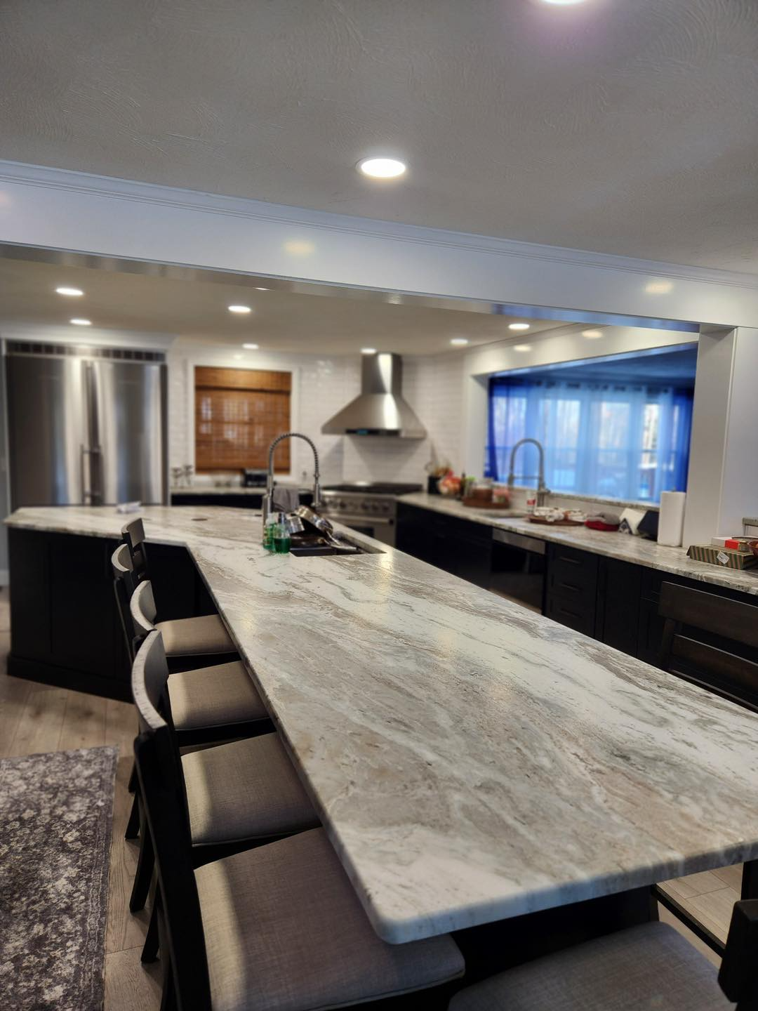 A kitchen with marble counter tops and stainless steel appliances