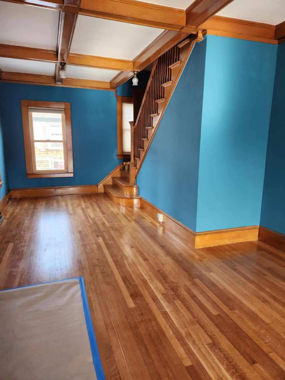 A living room with blue walls and hardwood floors
