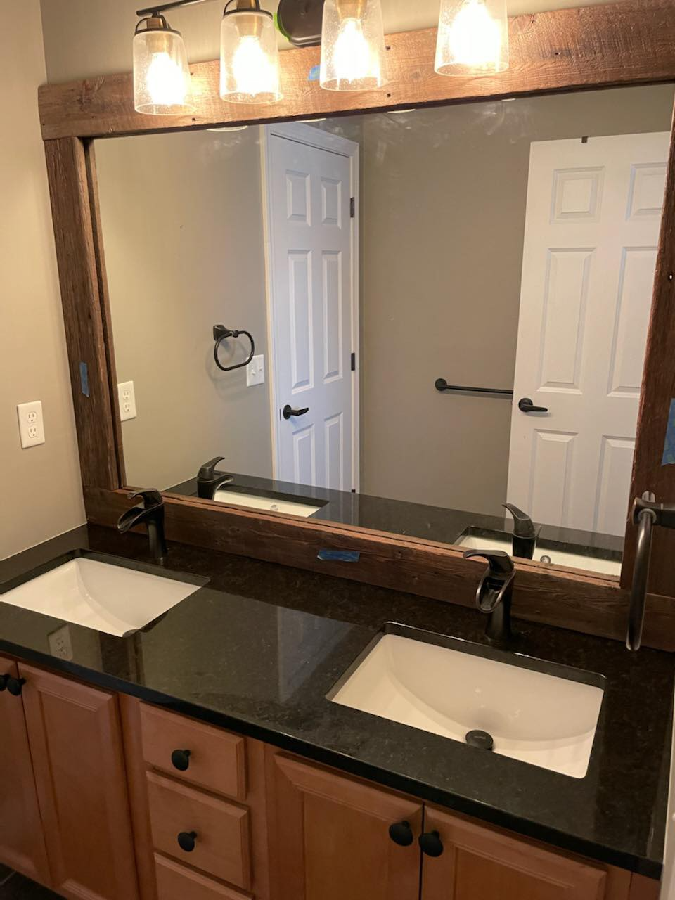 A bathroom with two sinks and a large mirror.