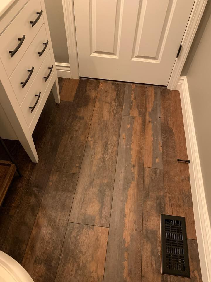 A bathroom with a wooden floor and a dresser.