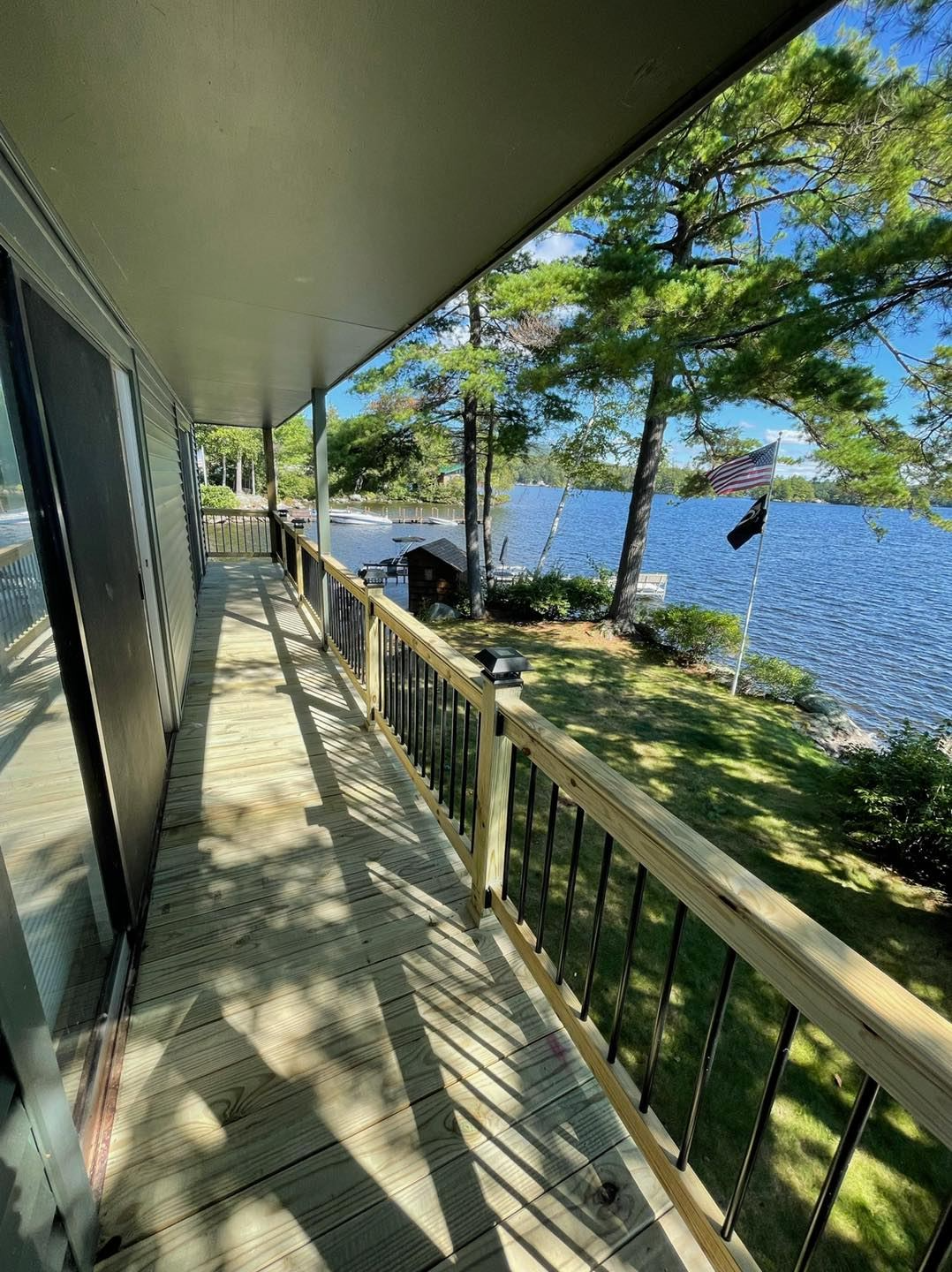 There is a large deck with a view of a lake.