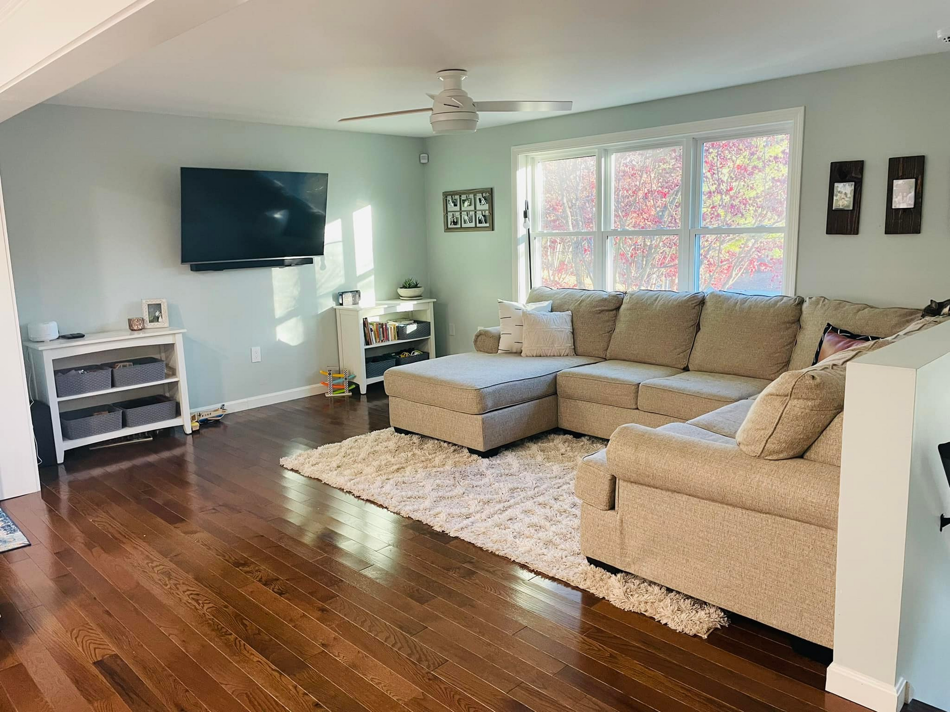 A living room with a sectional couch and a flat screen tv.