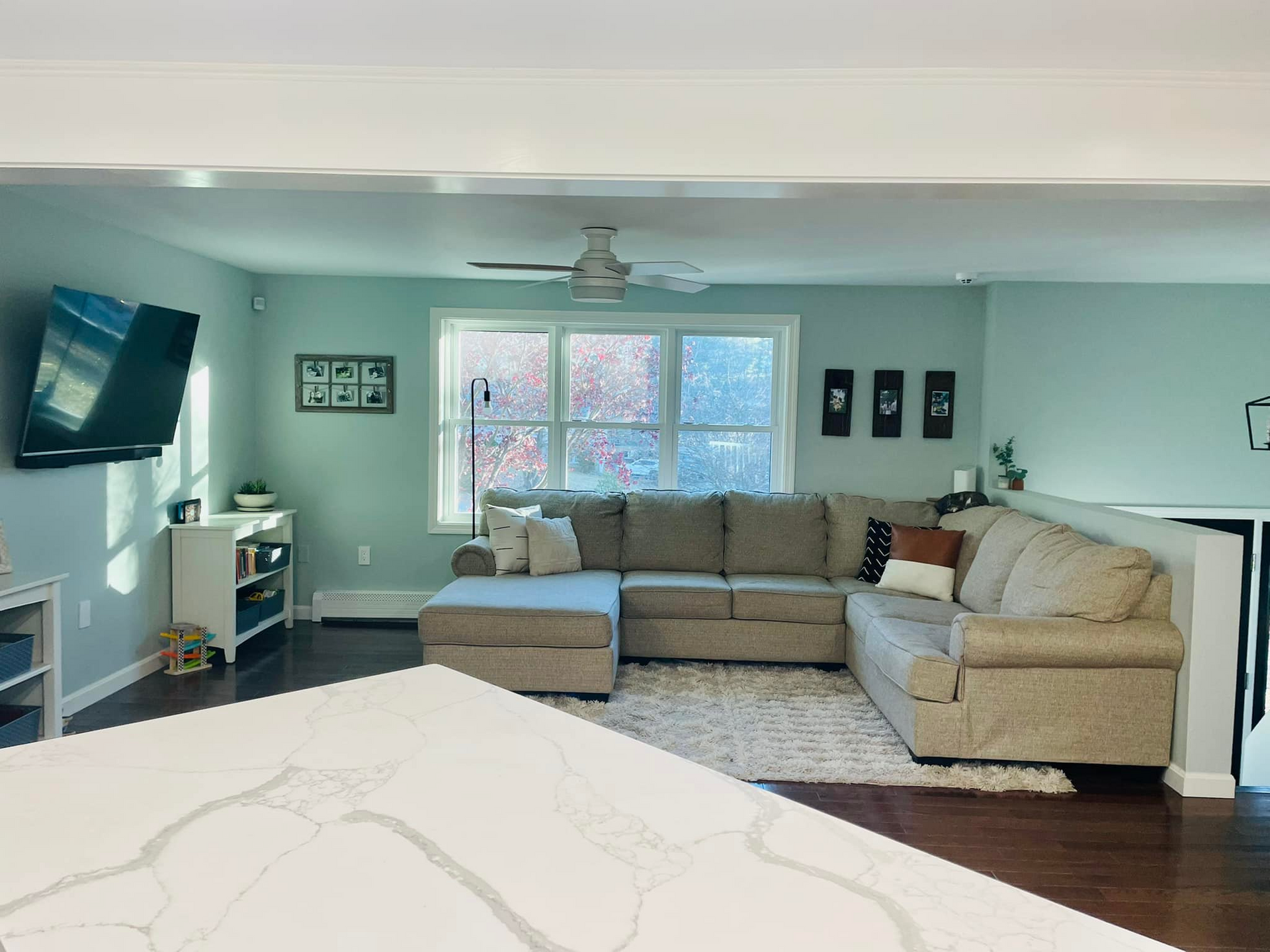 A living room with a large sectional couch and a flat screen tv.