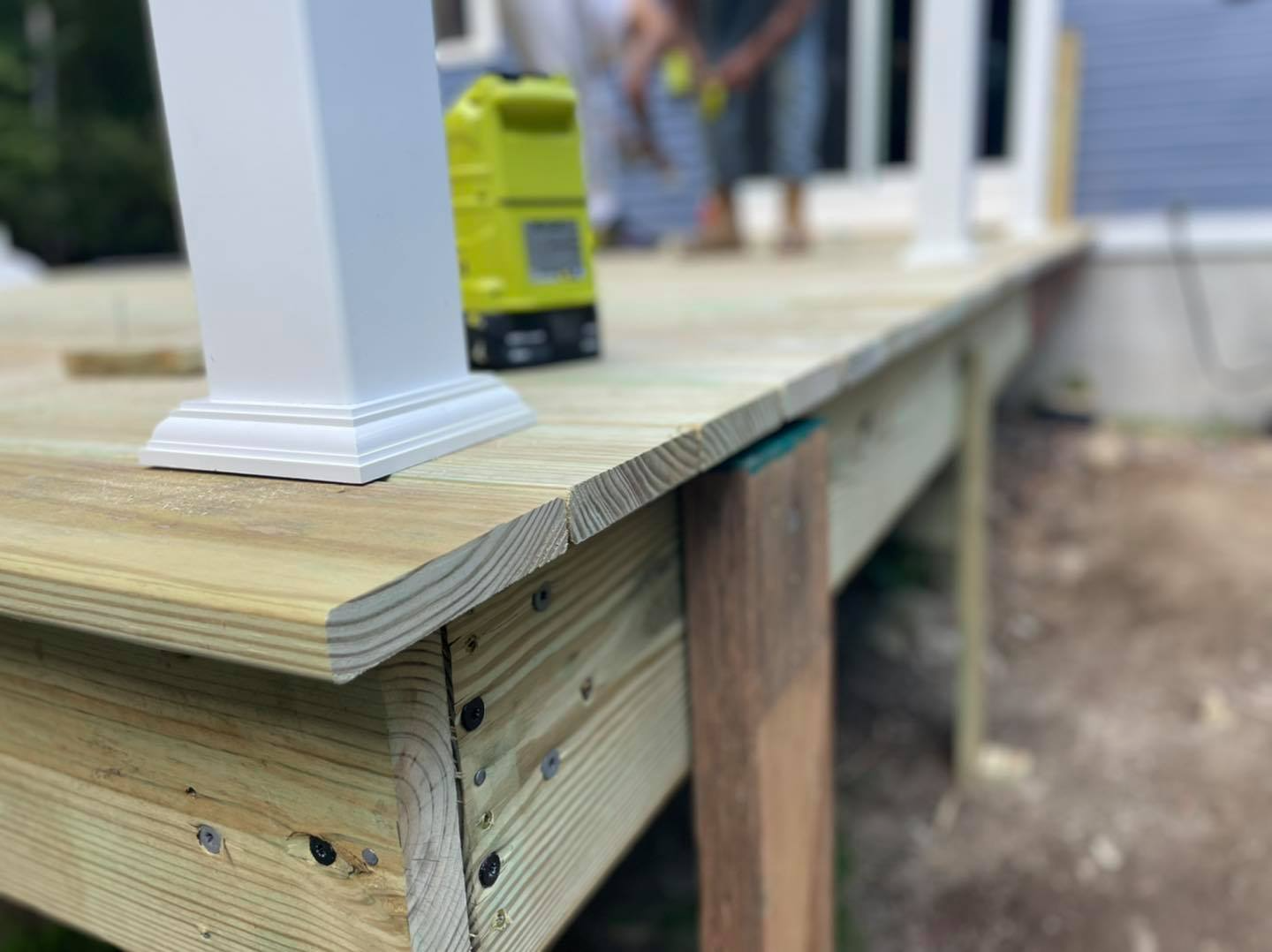 A wooden deck is being built next to a house.