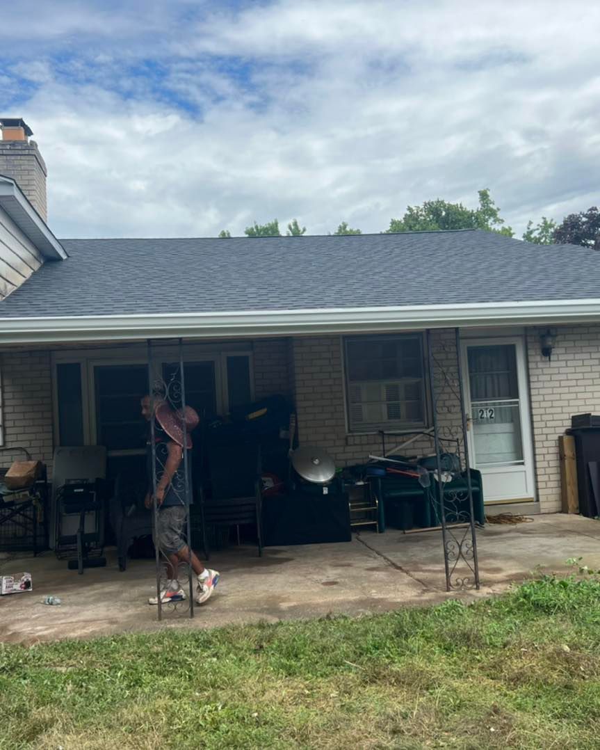 A man is standing on a patio in front of a house.