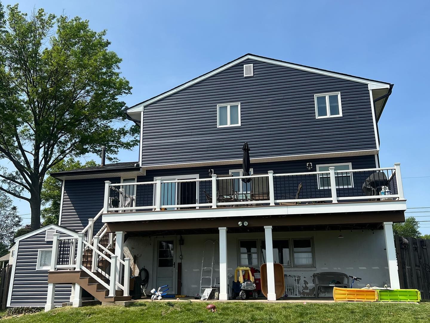 The back of a house with a large deck and stairs.