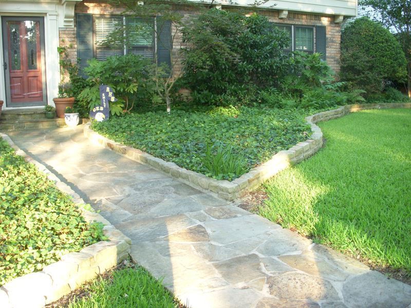A stone walkway leads to the front door of a house