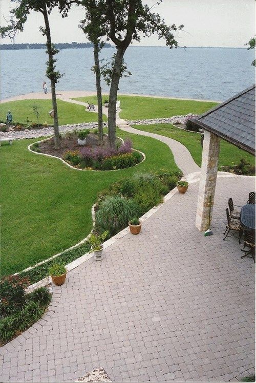A patio with a table and chairs overlooking a lake