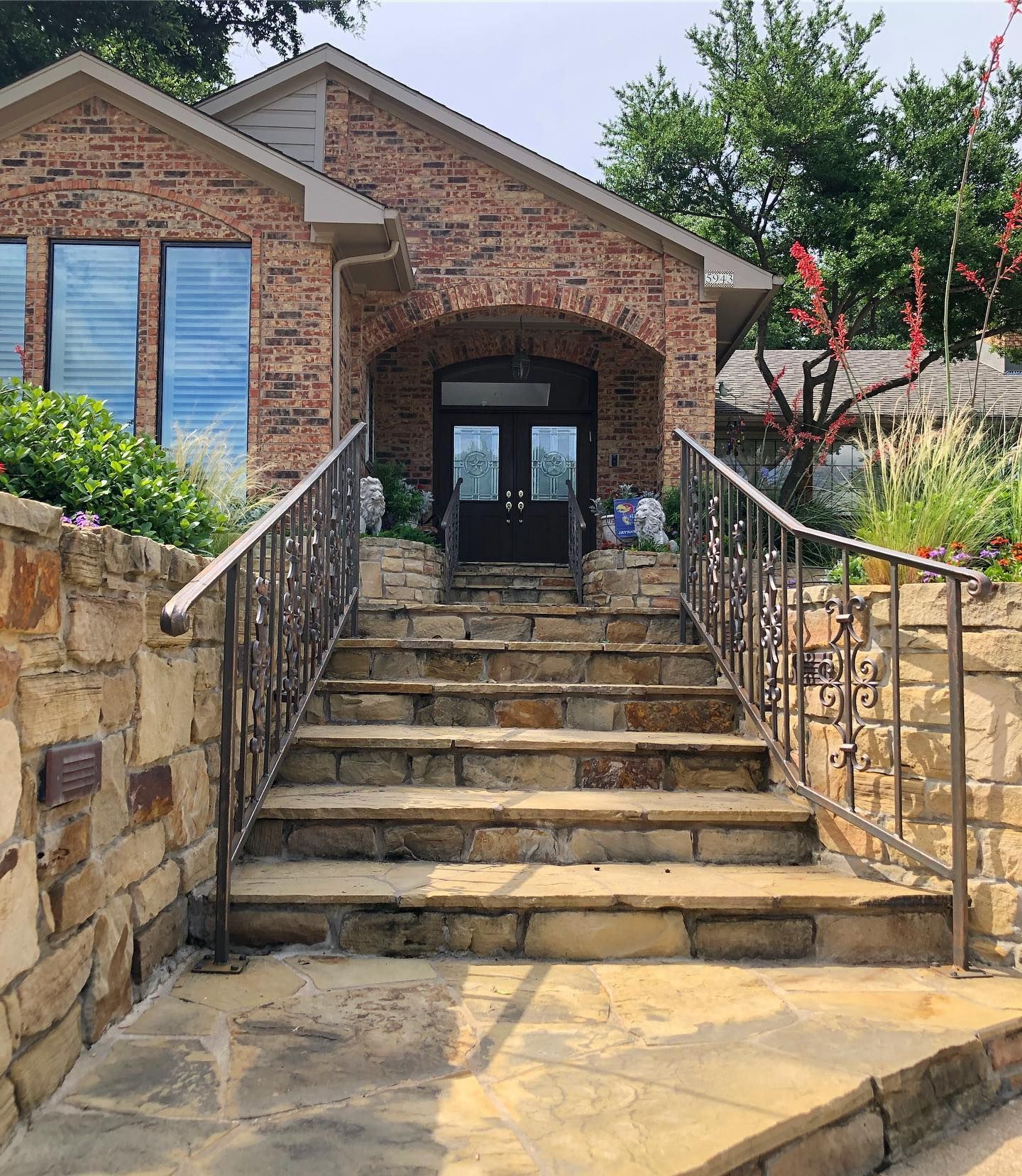 A brick house with stairs leading up to the front door