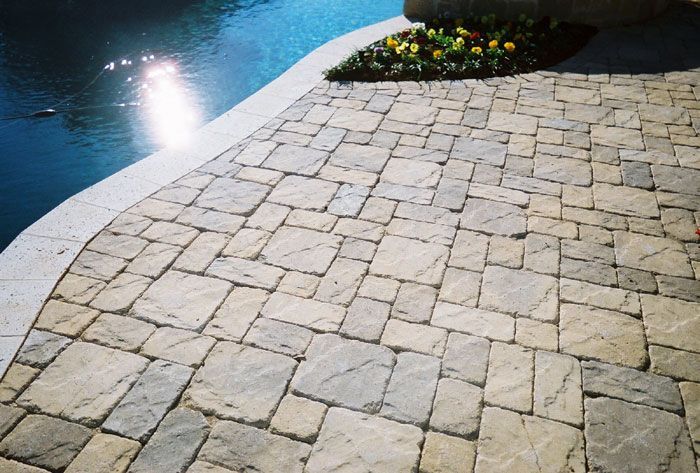 a brick walkway leading to a swimming pool