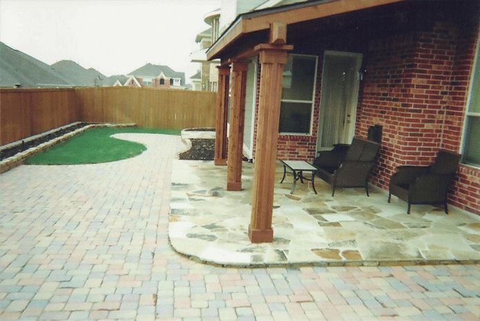 a brick house with a patio with chairs and a table