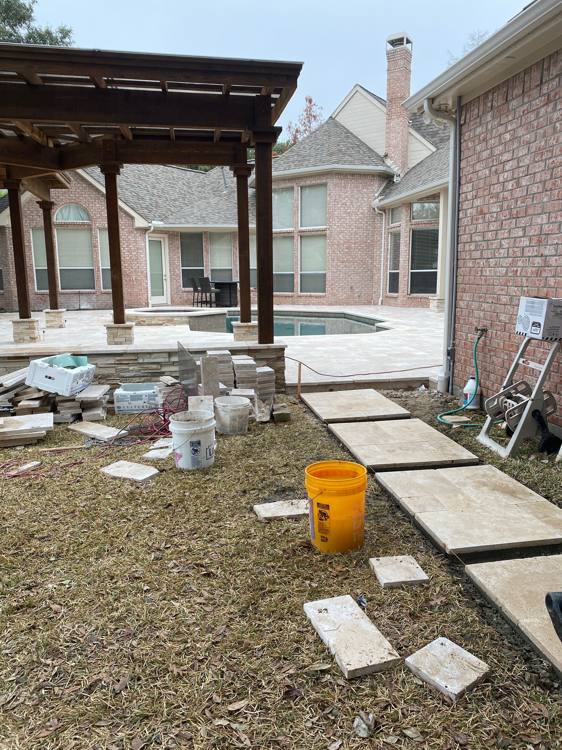 A brick house with a pool in the backyard is being remodeled.