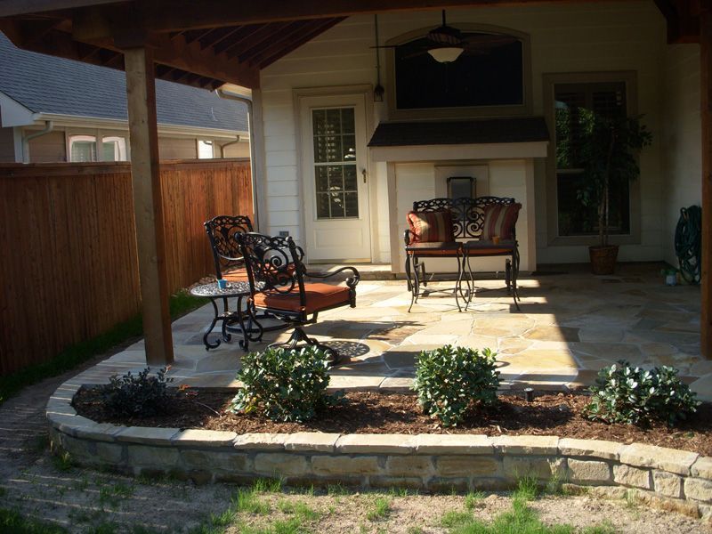 a patio with chairs and a table under a covered area