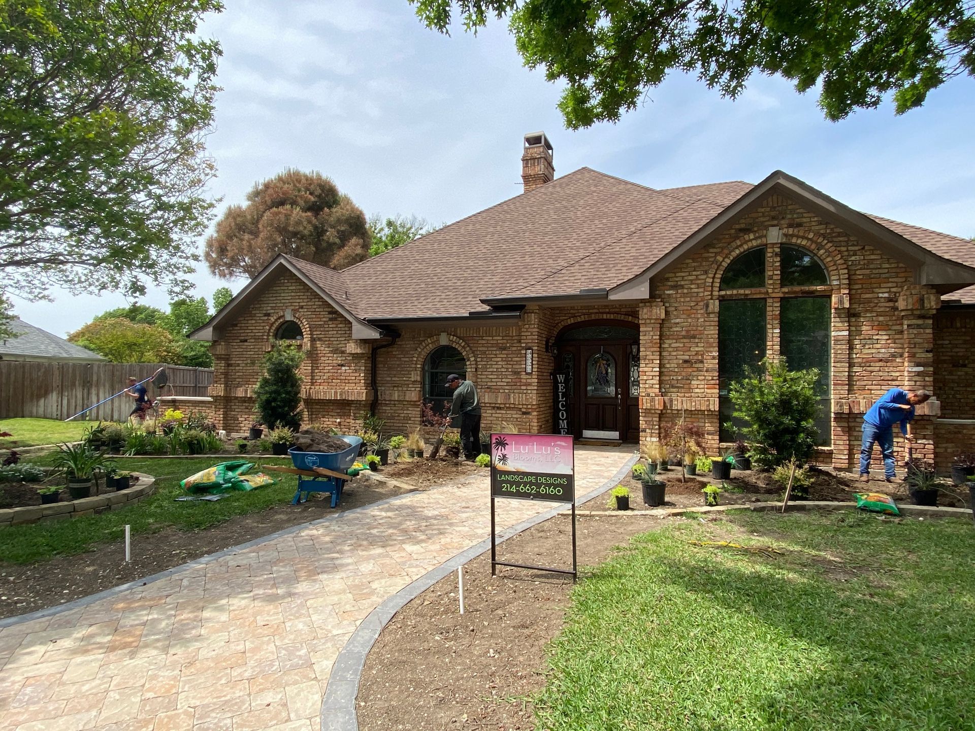 A brick house with a for sale sign in front of it.