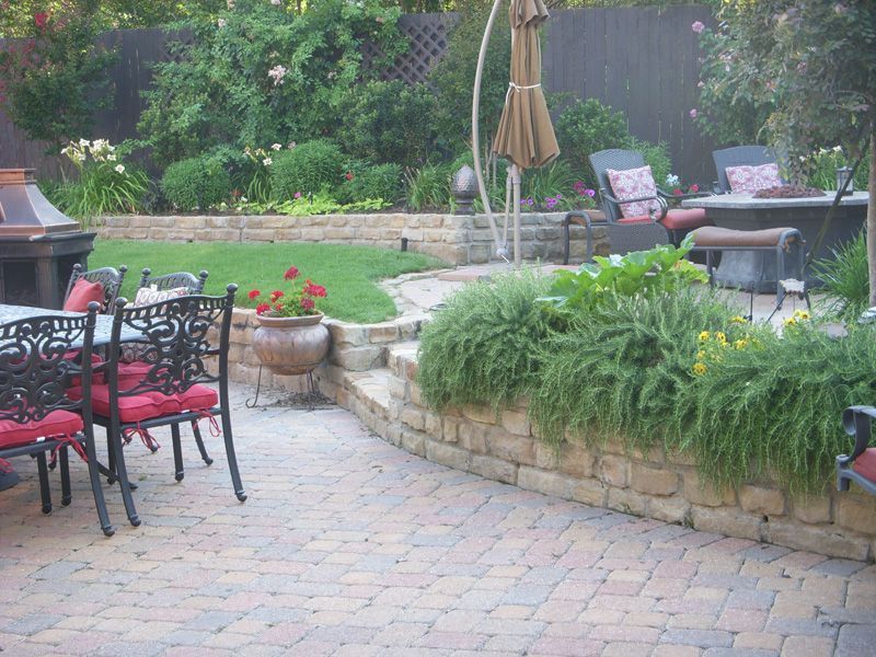 a patio with a table and chairs and a fire pit