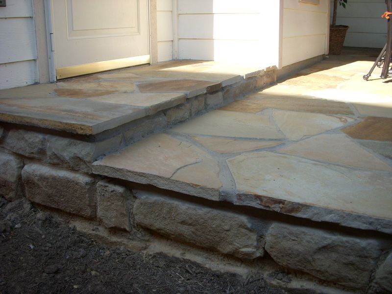 a stone walkway with steps leading up to a house
