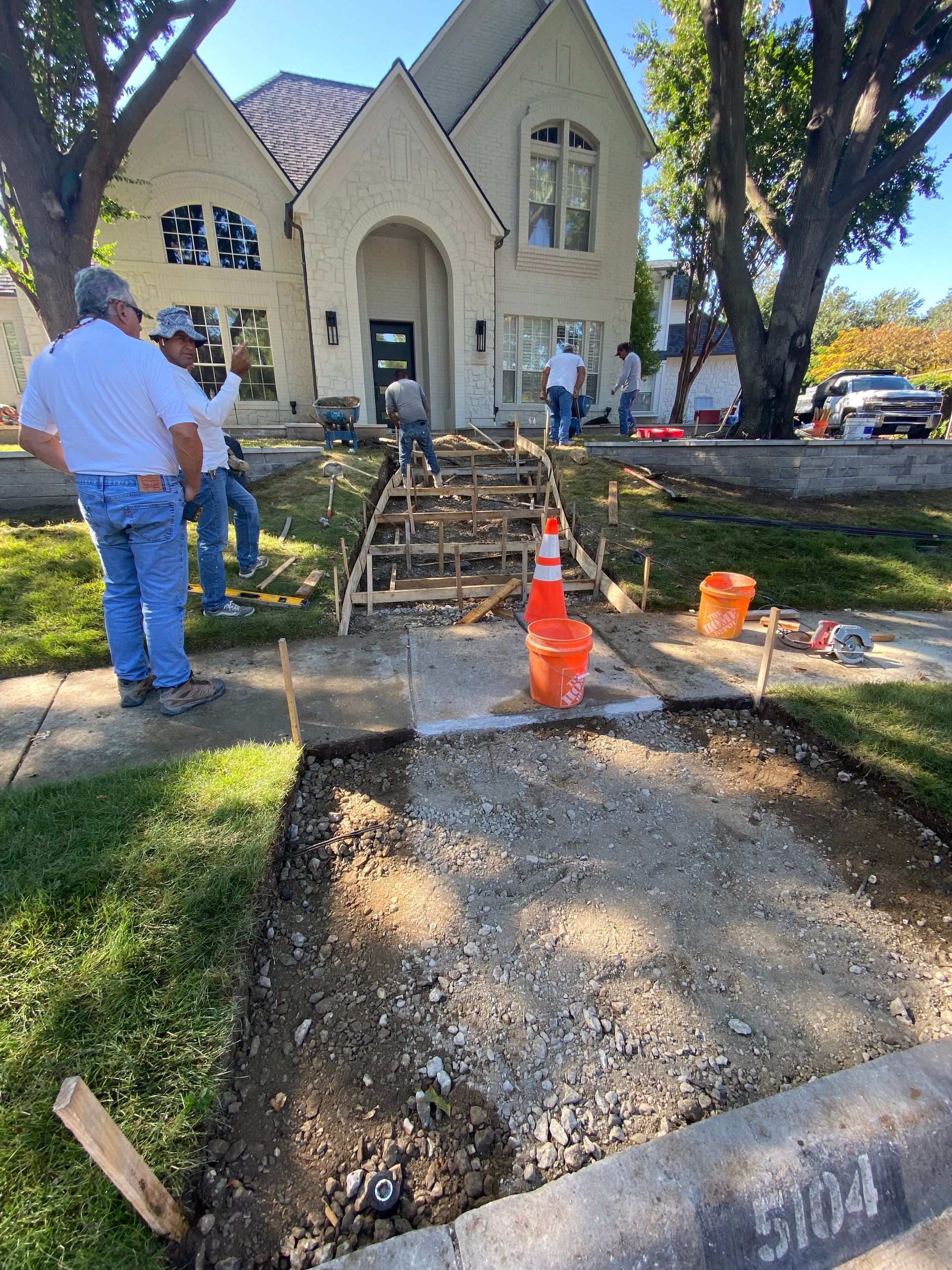 A group of men are standing in front of a house.