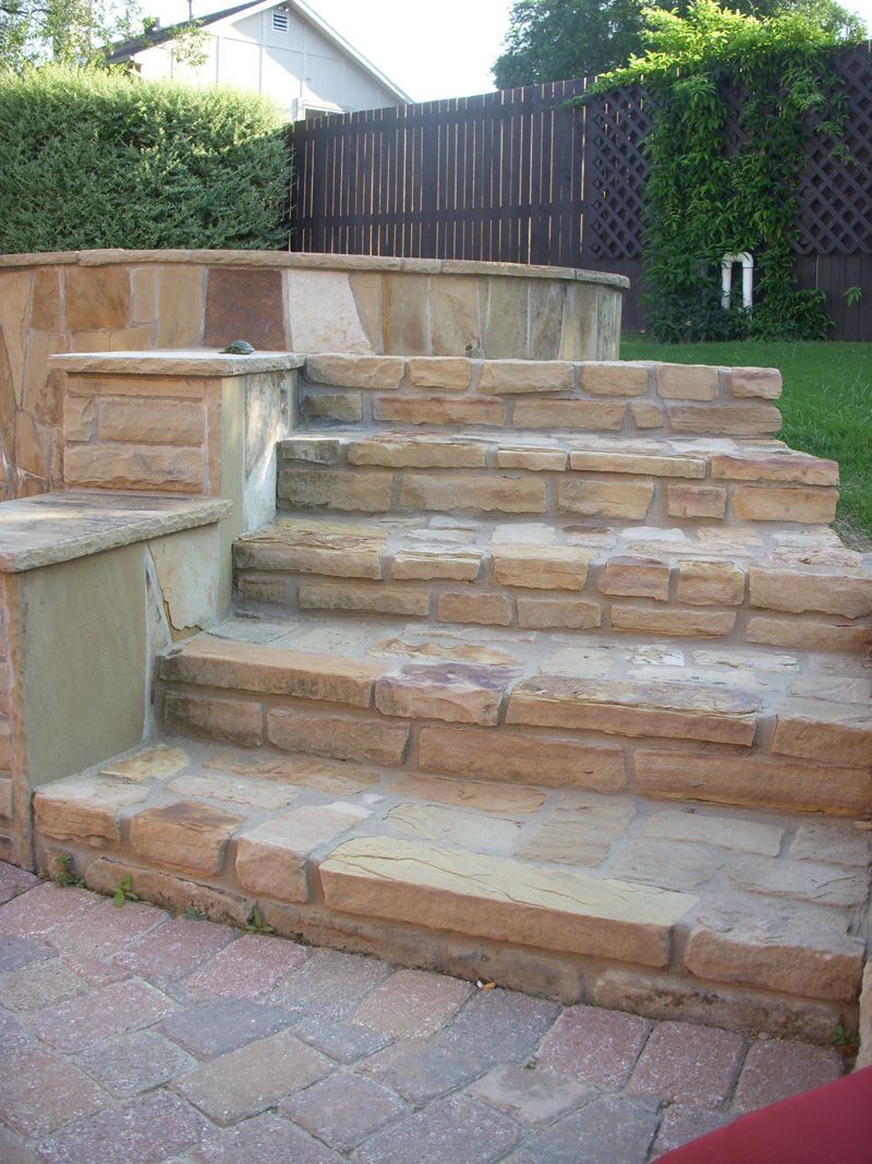 a set of stone stairs leading up to a fence