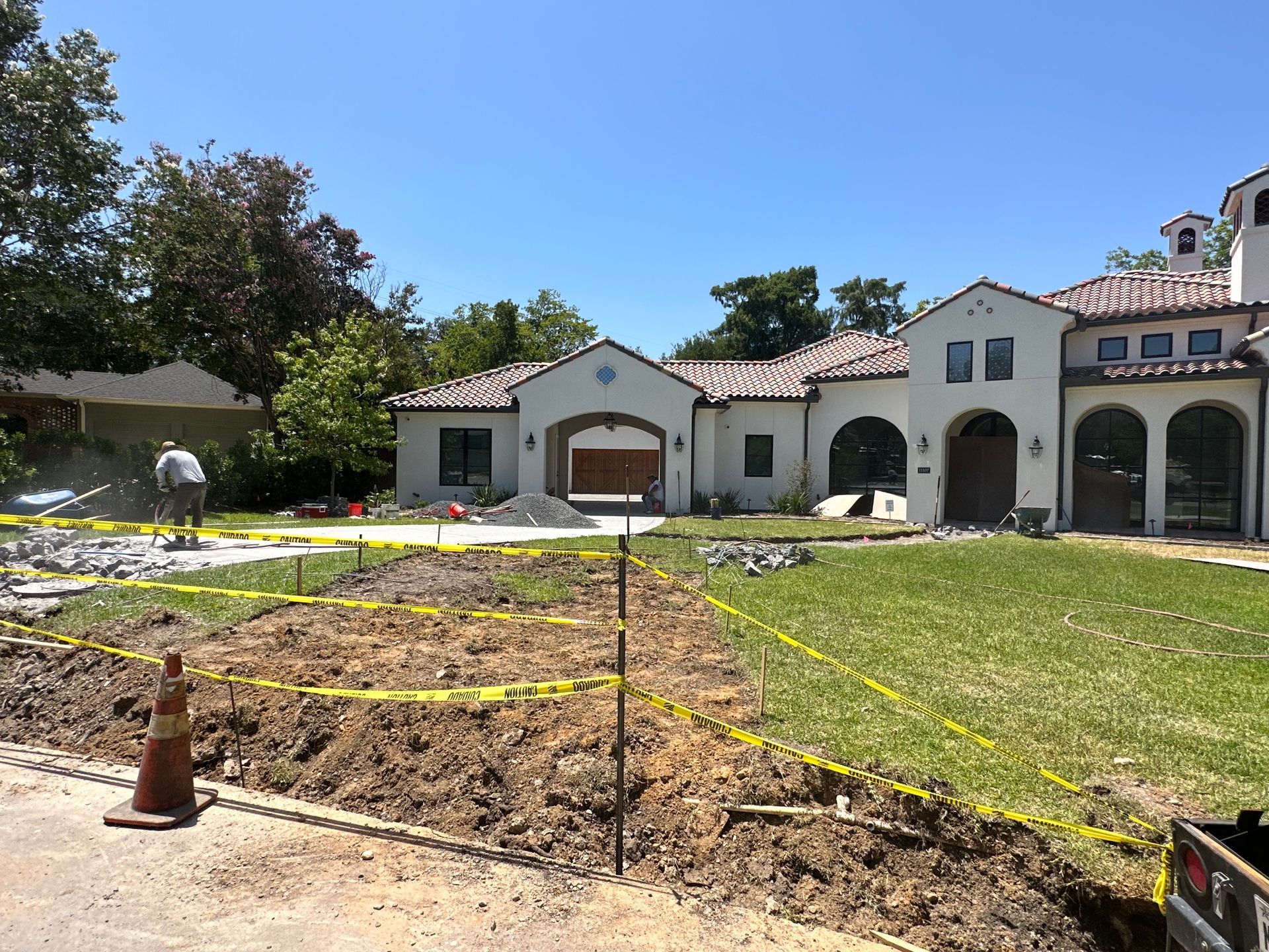 A large white house is under construction with a lot of dirt in front of it