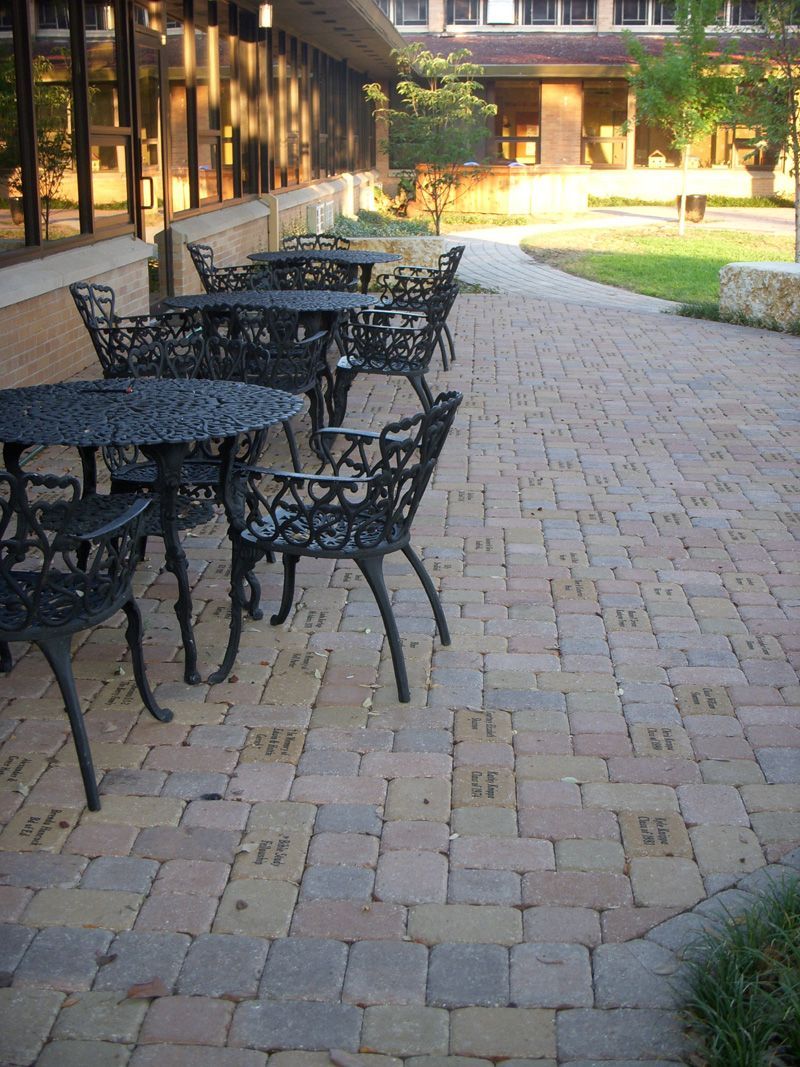 a patio with tables and chairs in front of a building