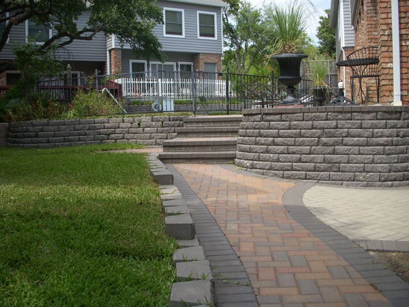 a brick walkway with stairs leading up to a house