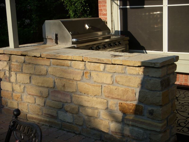 a brick wall with a grill on top of it