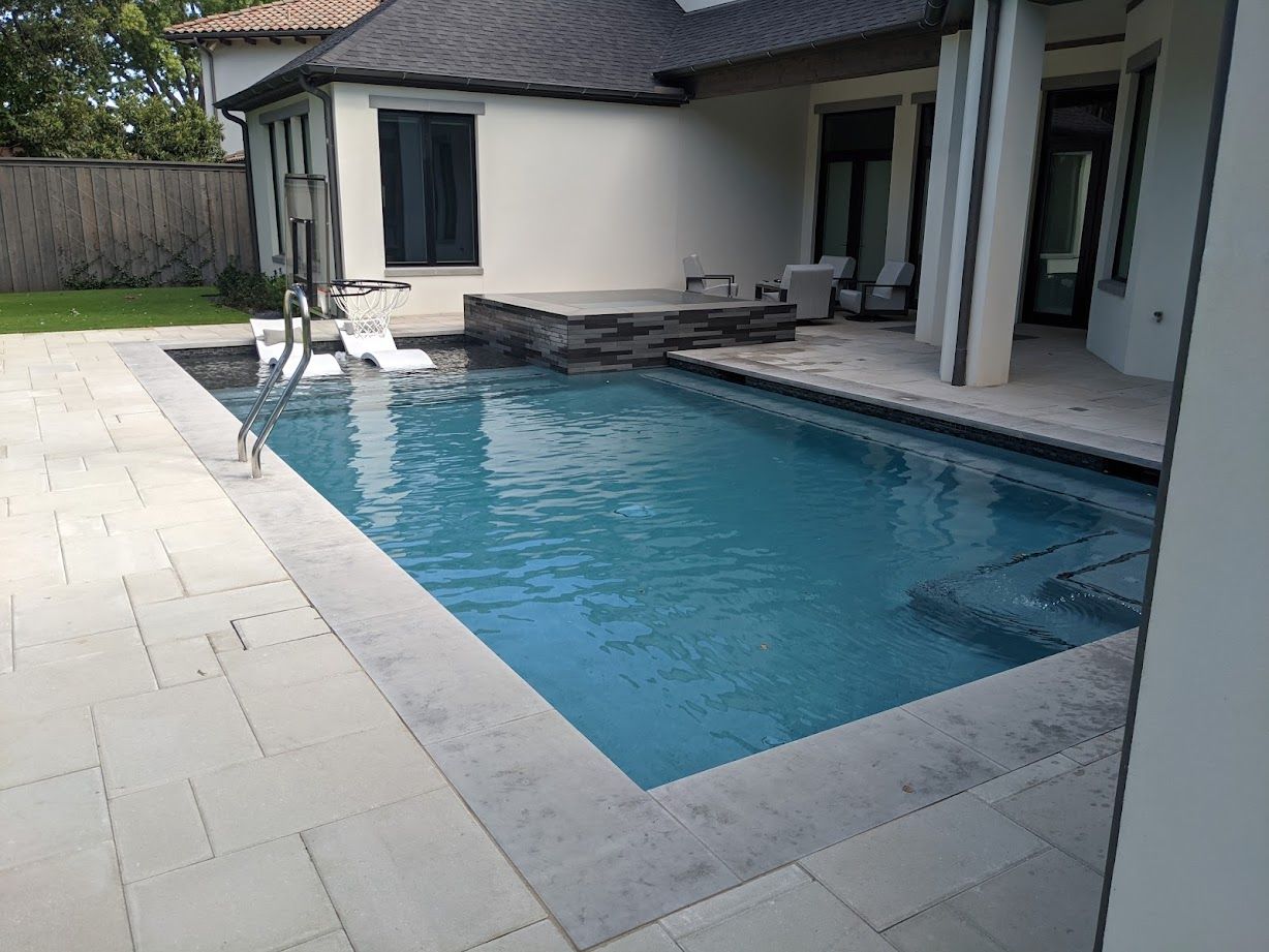 A large swimming pool is in the backyard of a house.