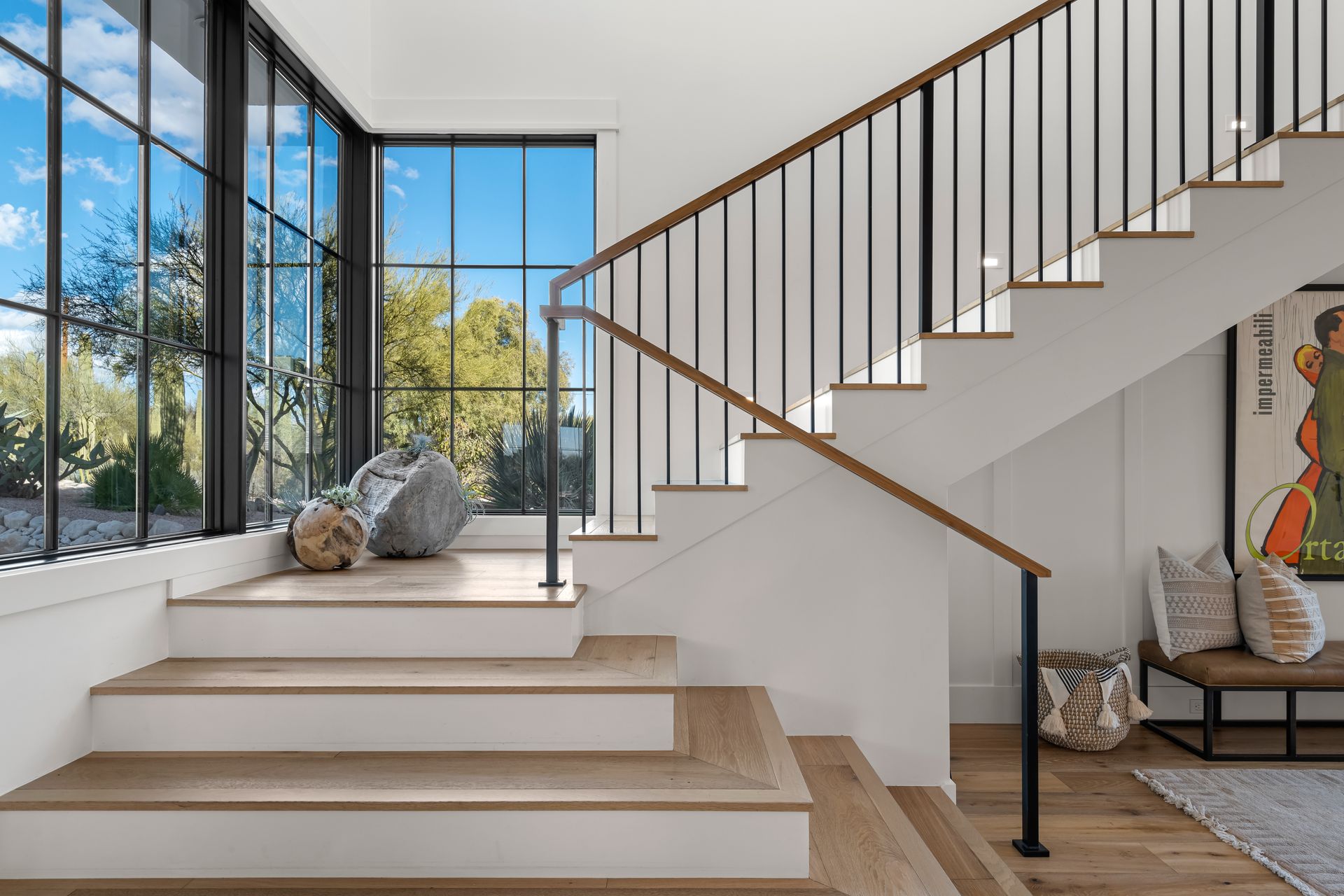 A staircase with a wooden railing and a large window in a house.