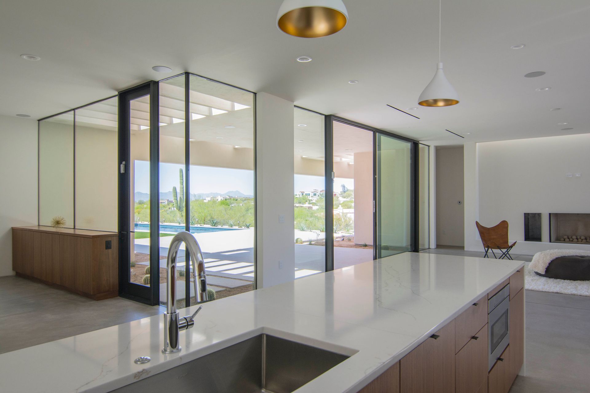 A kitchen with a sink and sliding glass doors leading to a living room.