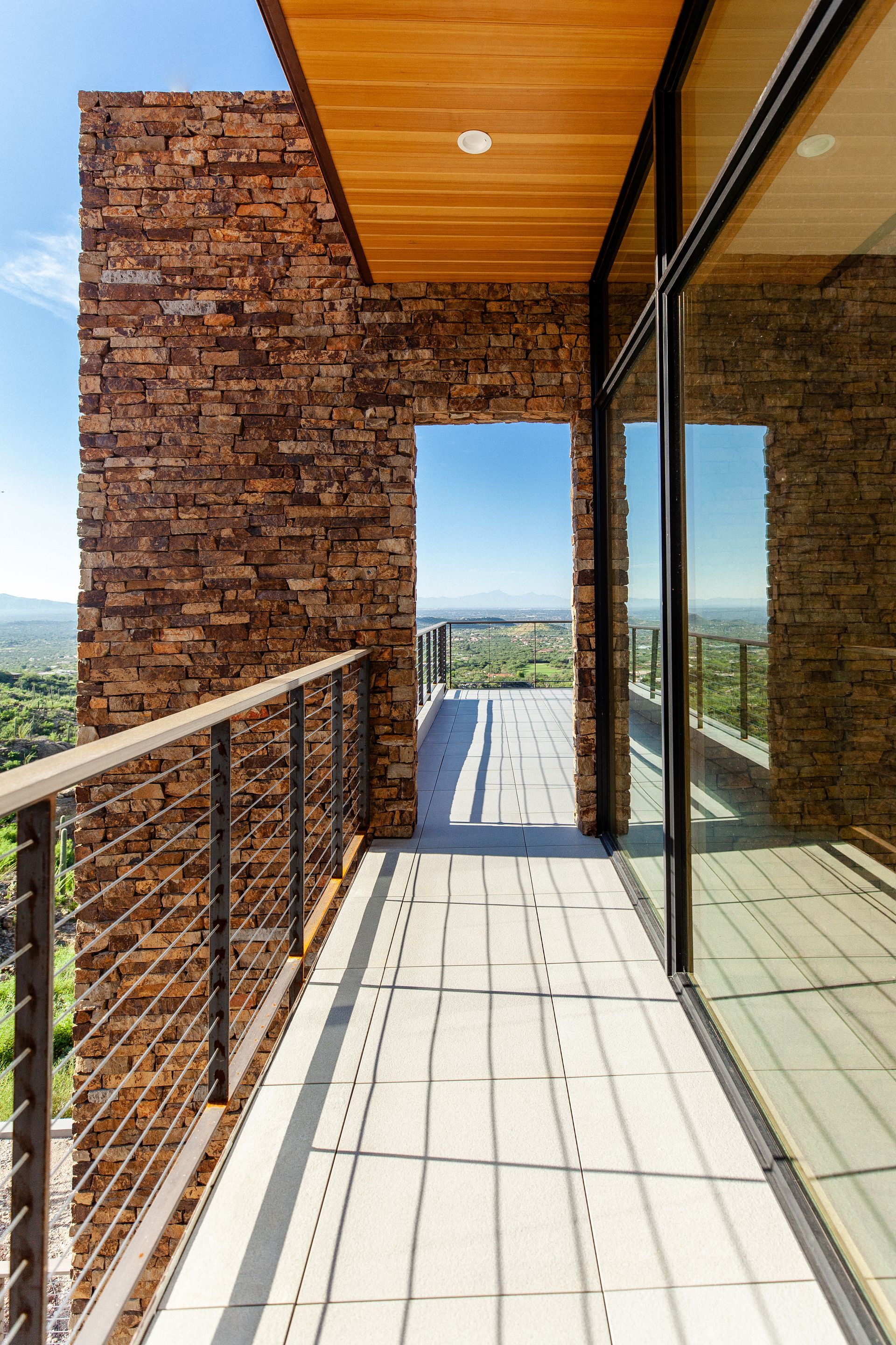 A balcony with a brick wall and sliding glass doors
