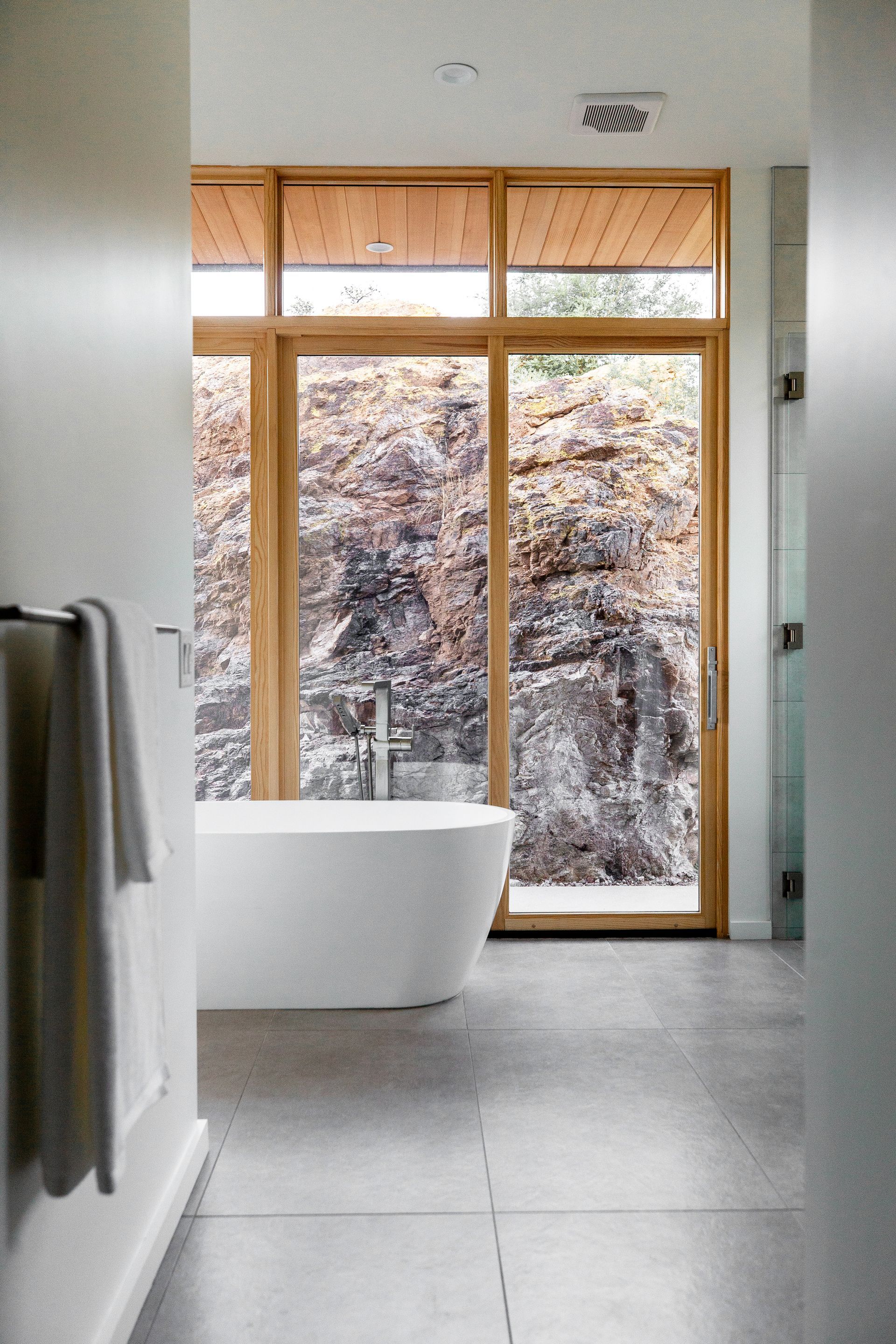 A bathroom with a bathtub and a large window.