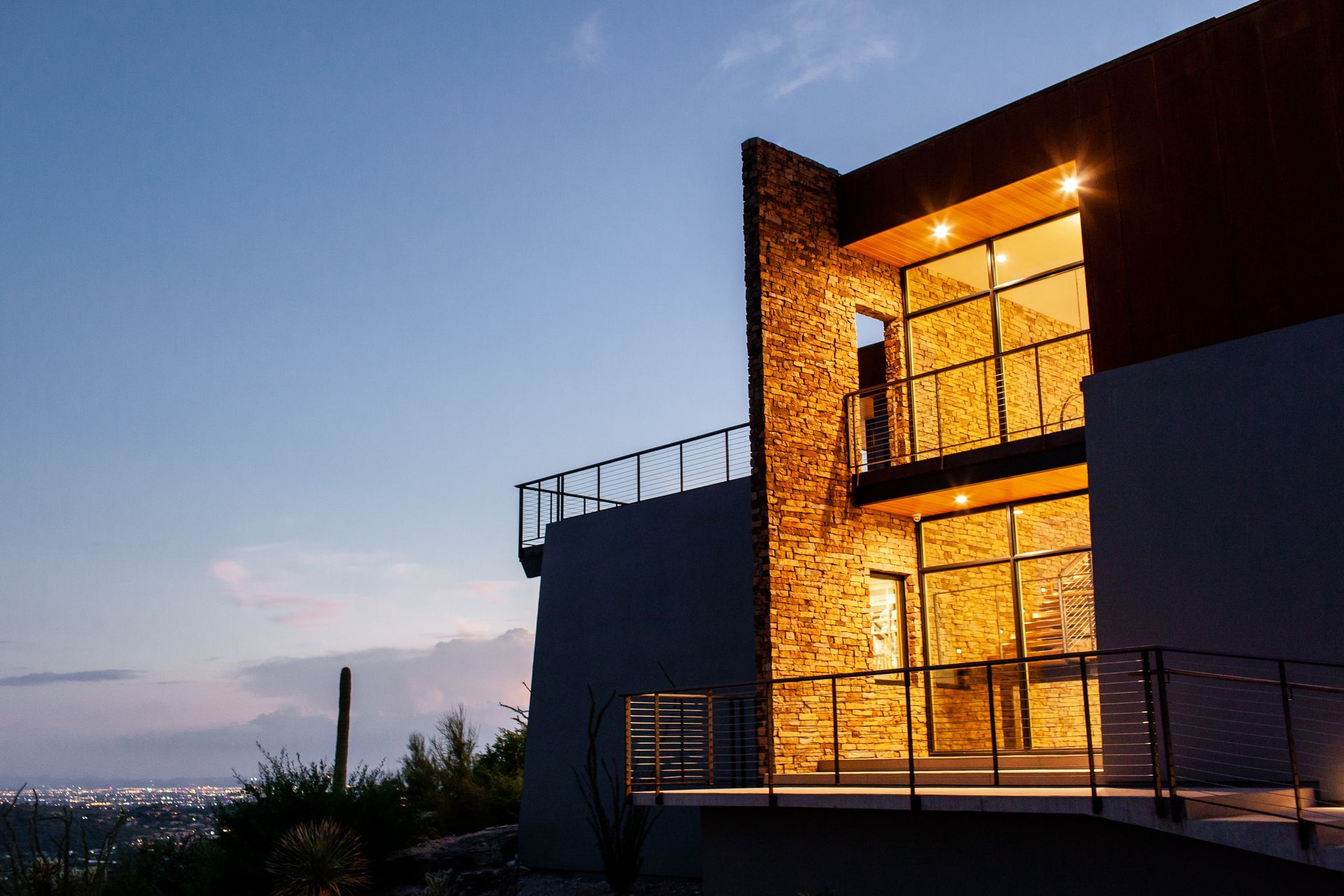 A large house with a balcony is lit up at night