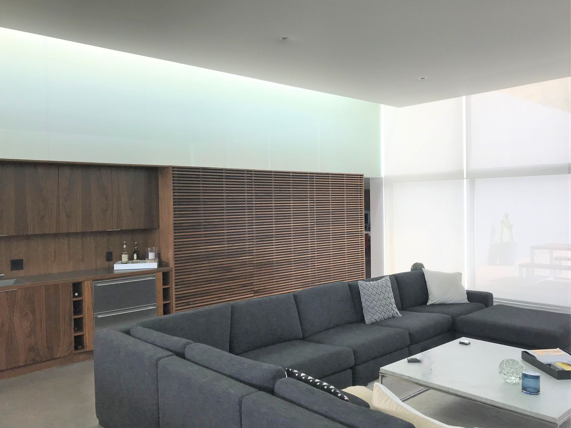 A living room with a large sectional couch and a white coffee table