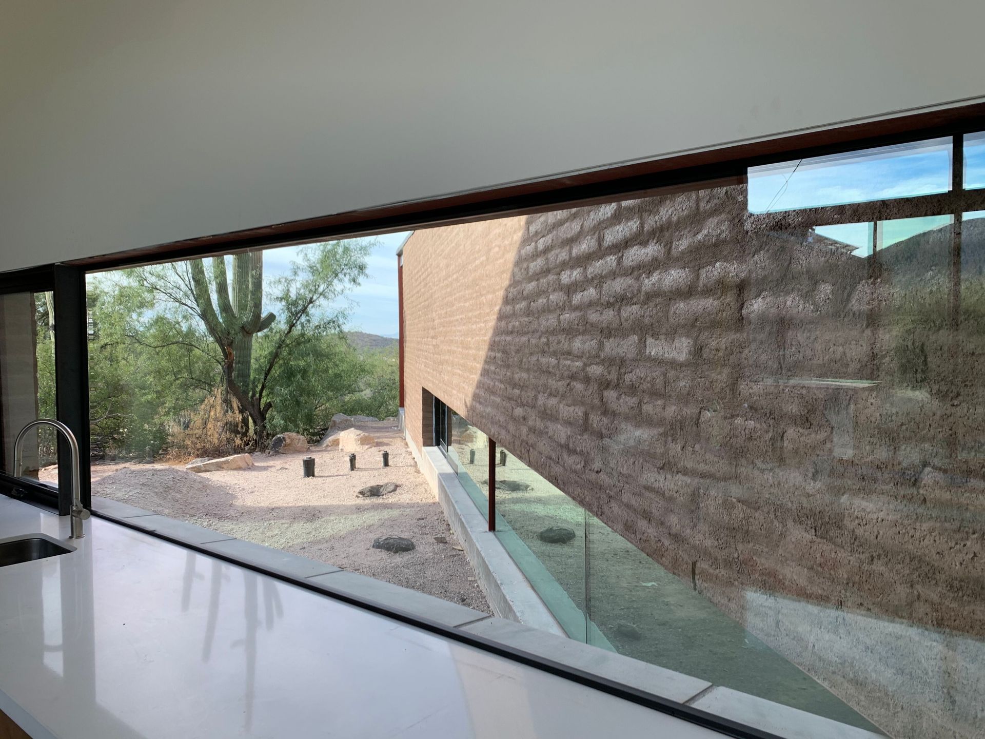 A kitchen with a large window and a brick wall.