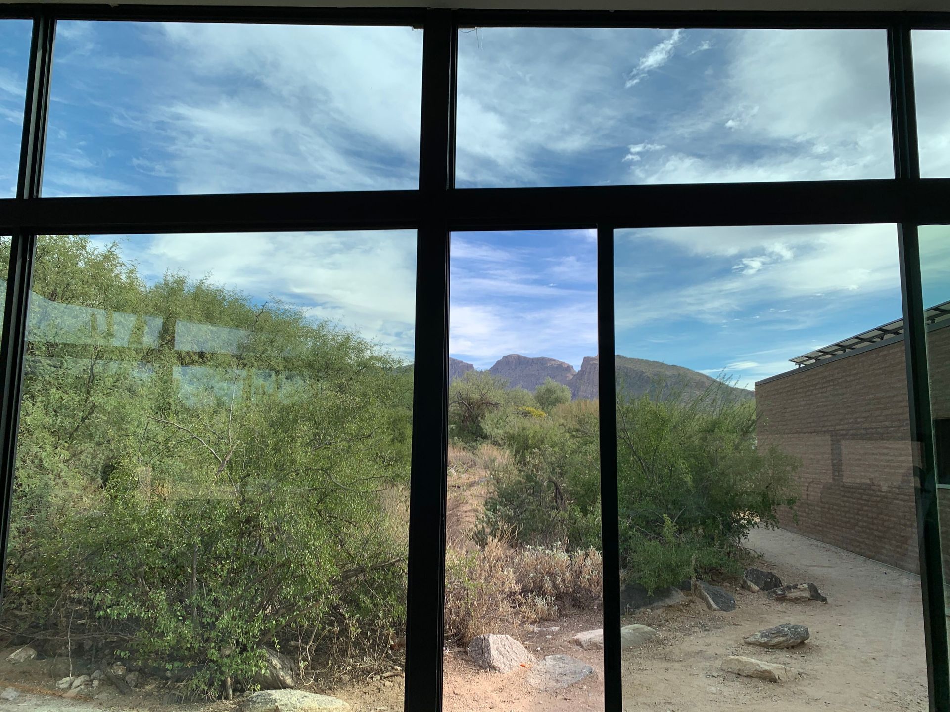 A window with a view of a mountain and trees