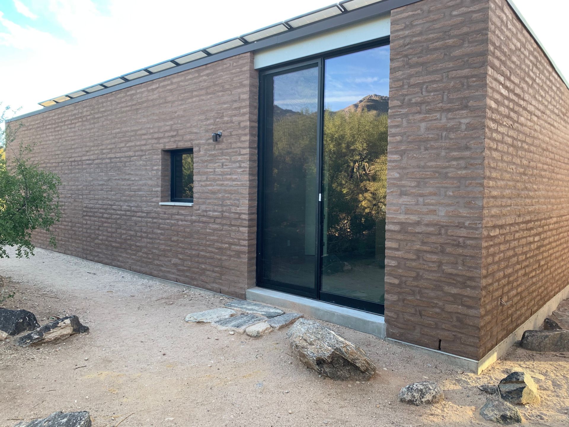 A brick building with a sliding glass door and a window.
