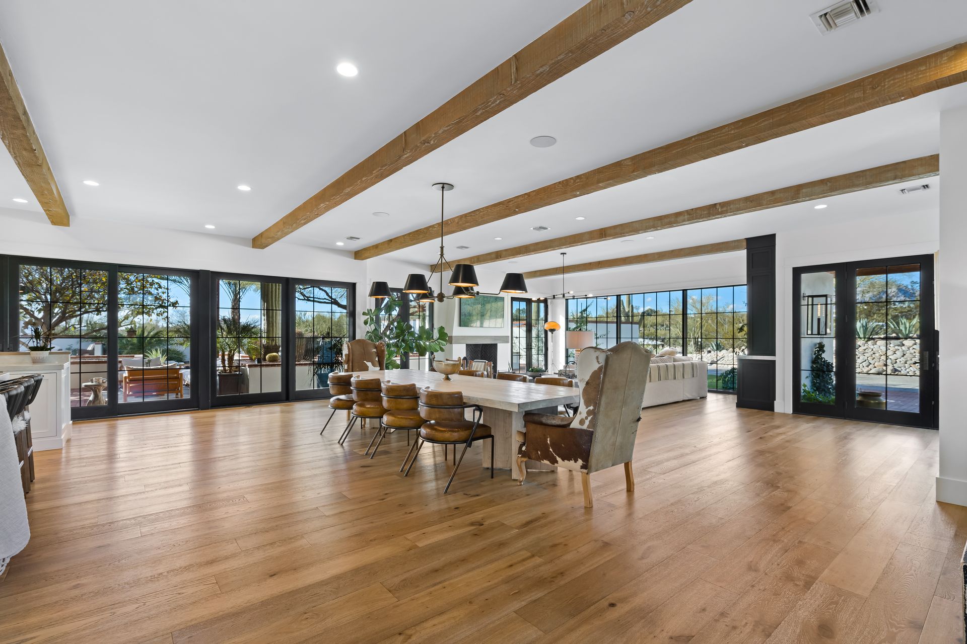 A large living room with hardwood floors, a table and chairs.