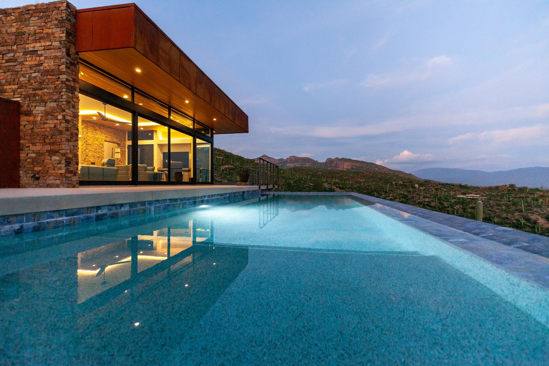 There is a large swimming pool in front of a house.