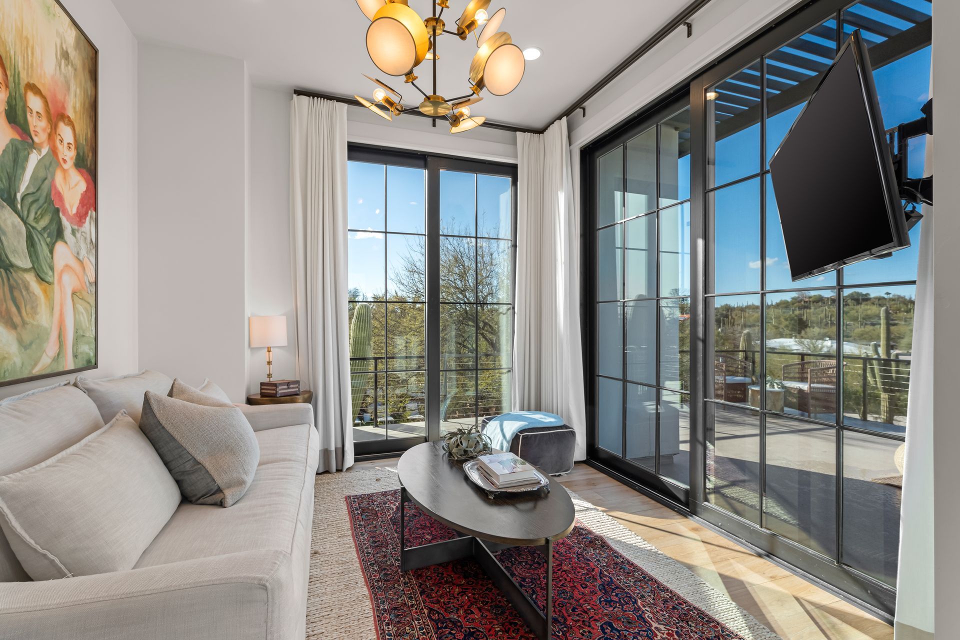 A living room with a couch, coffee table, television and sliding glass doors.