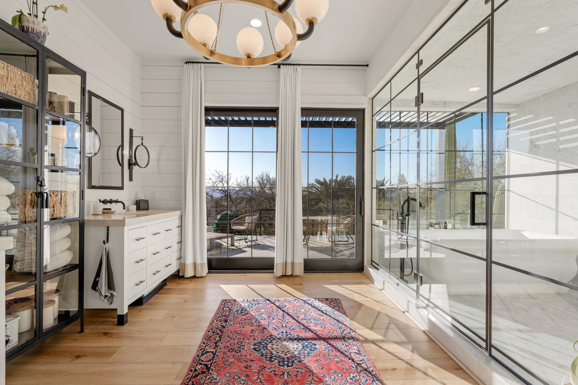 A bathroom with a bathtub, sink, and sliding glass doors.