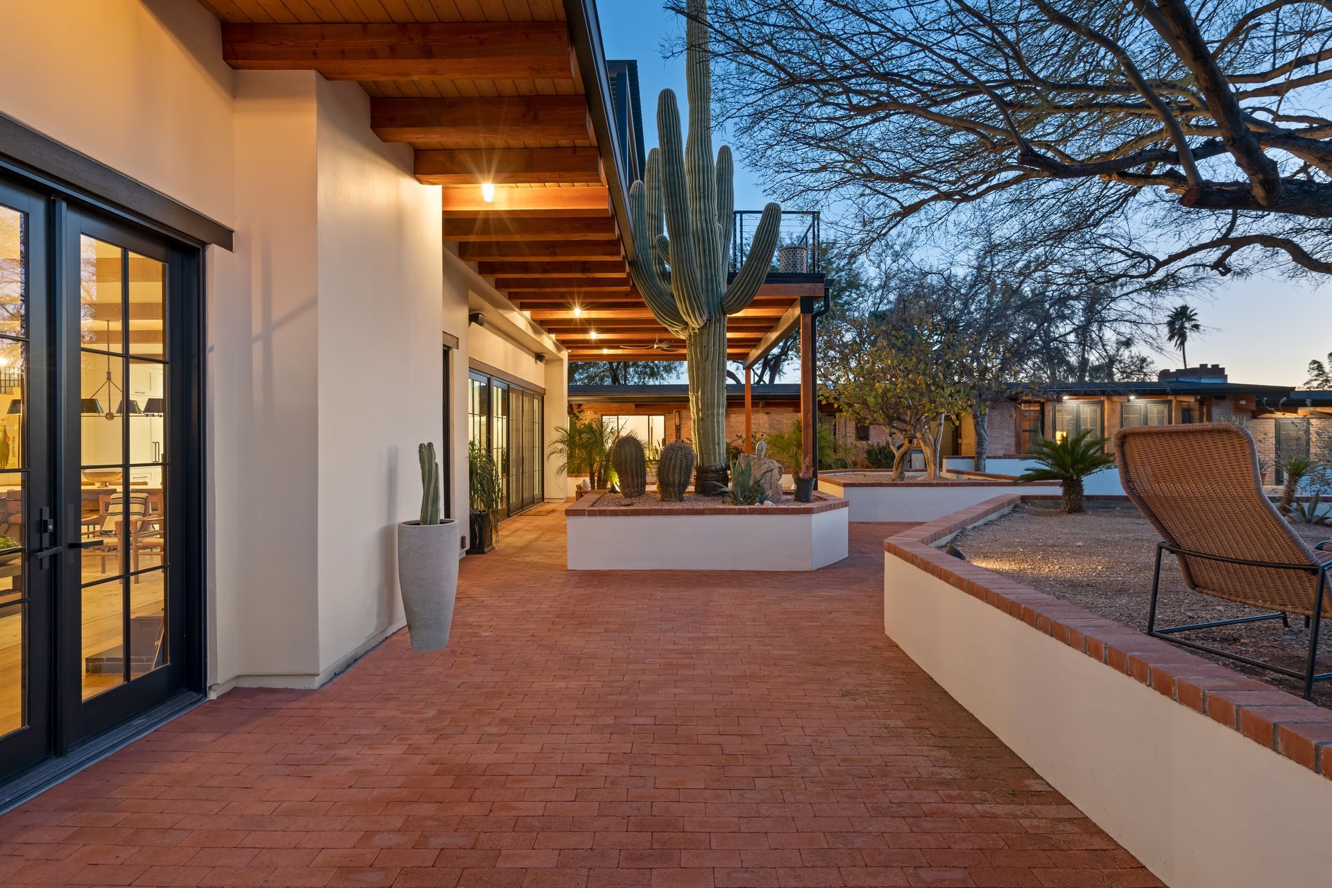A patio with a chair and a cactus in the middle of it