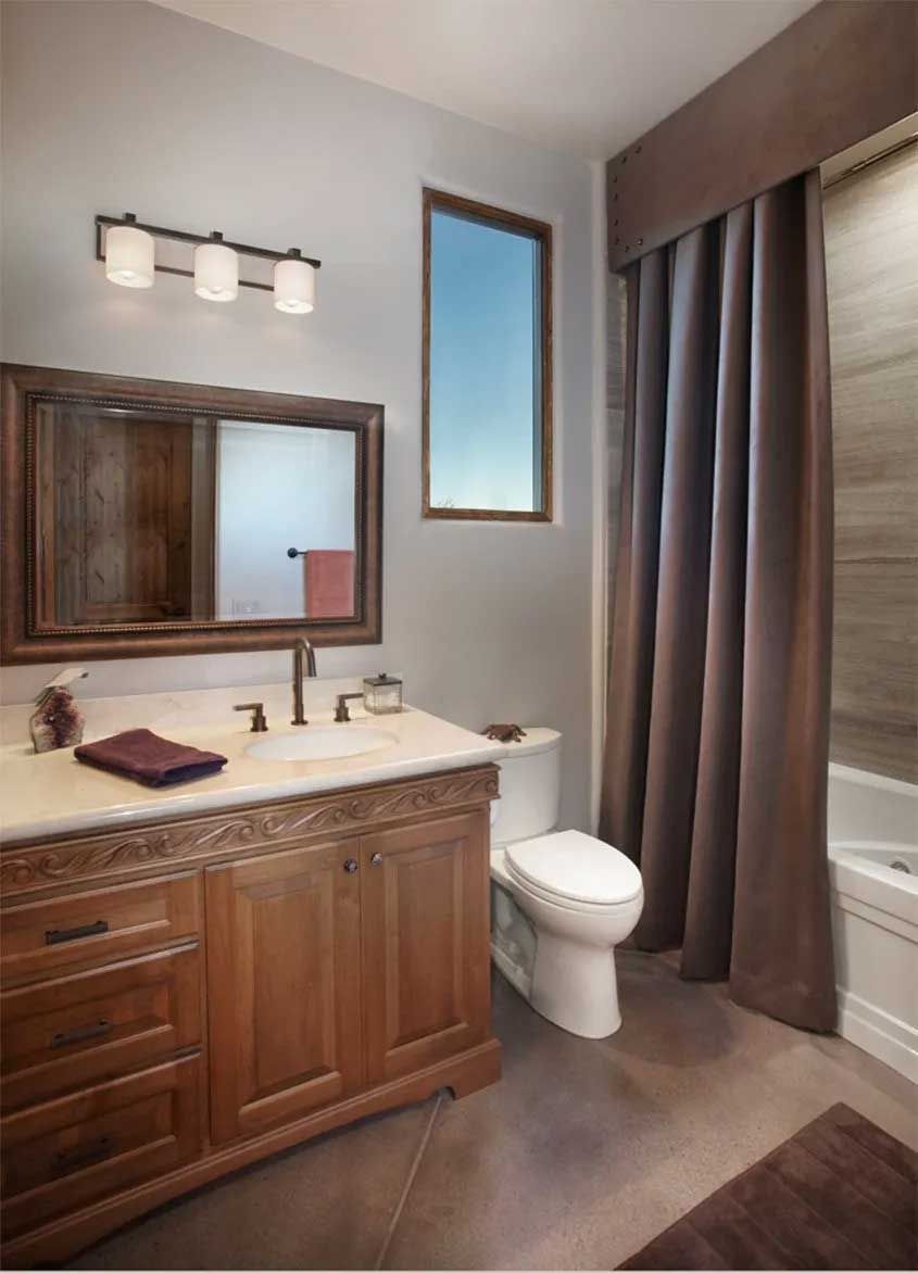 A bathroom with a toilet a sink a mirror and a window