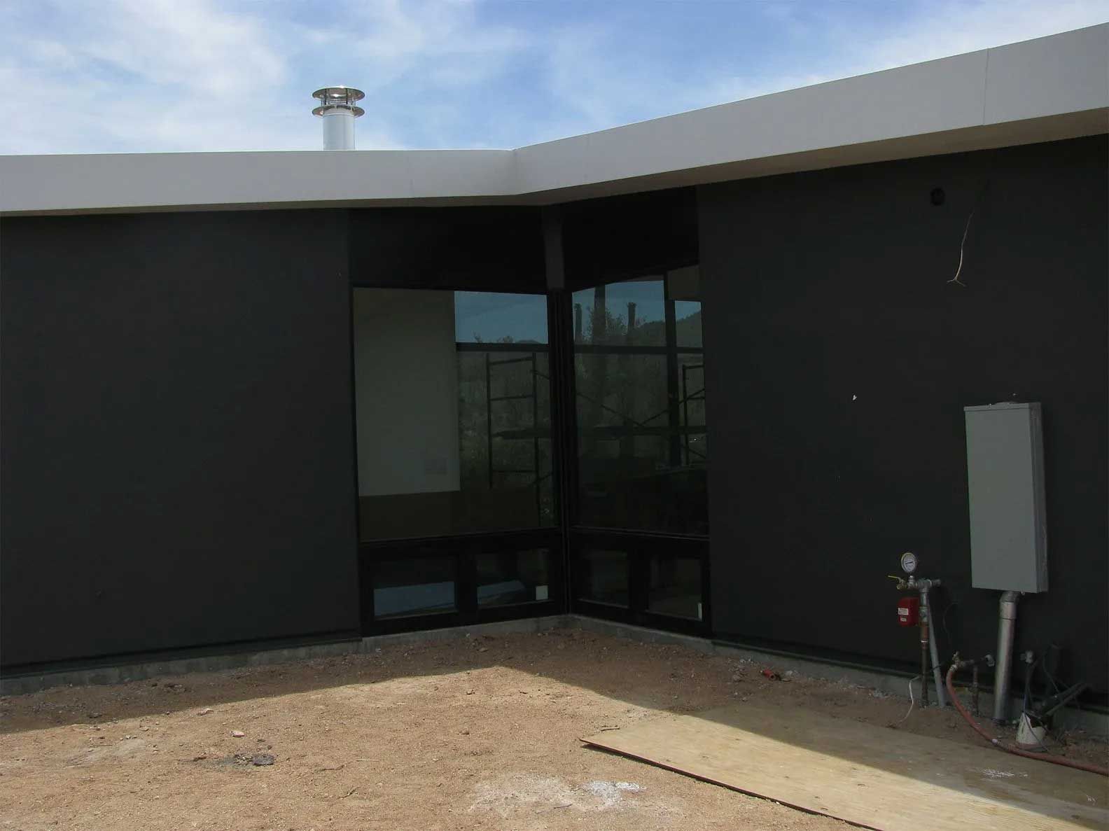 A black building with a chimney on top of it