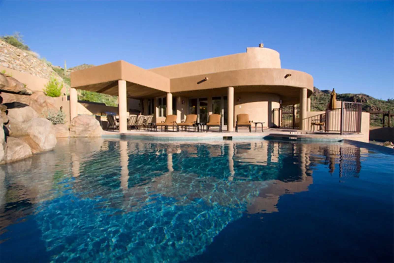 A large house with a swimming pool in front of it