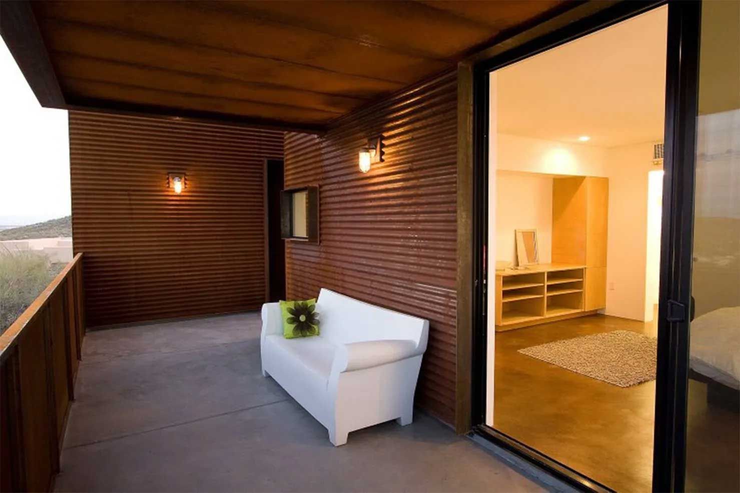 A balcony with a white couch and a sliding glass door