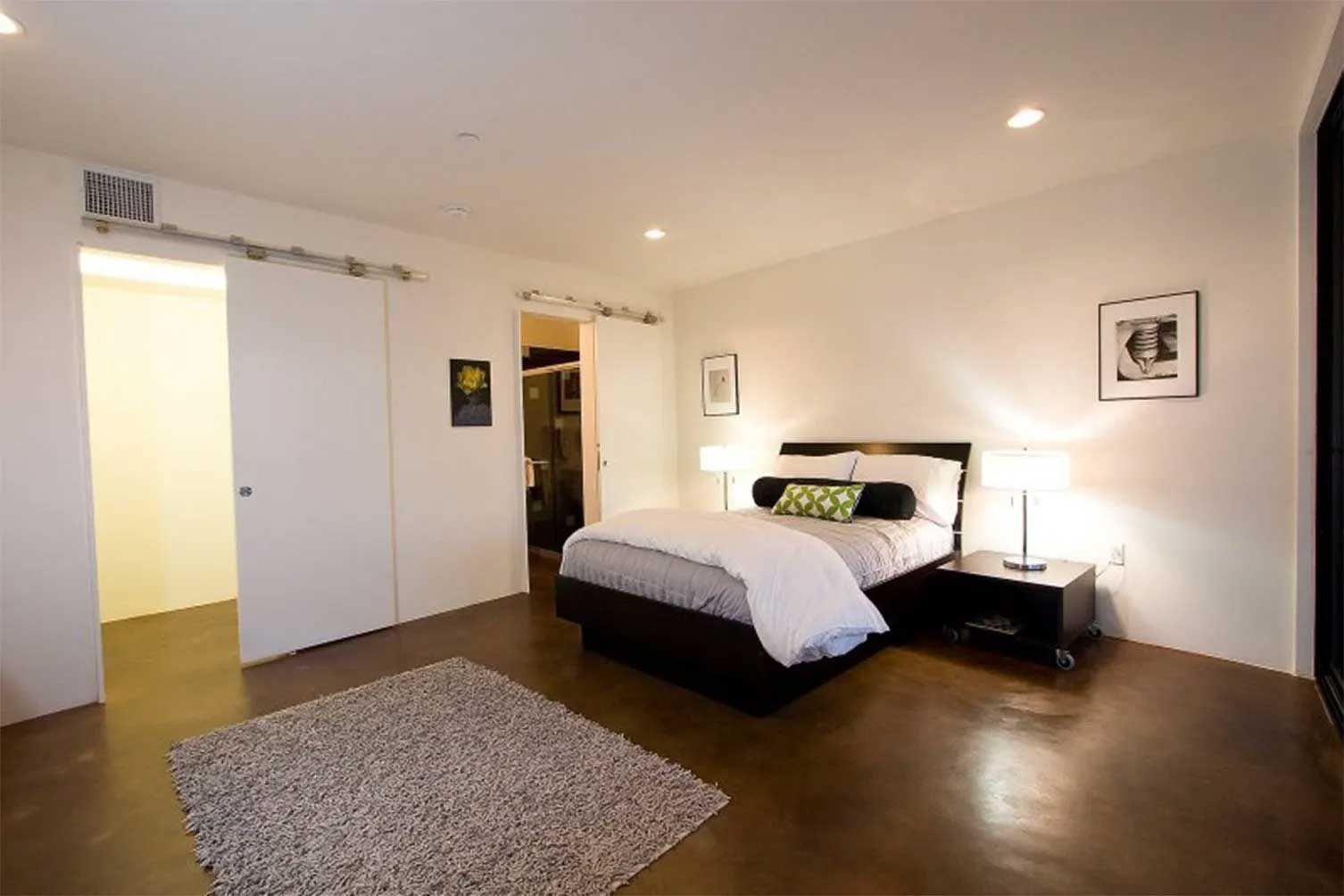 A bedroom with a large bed and a rug