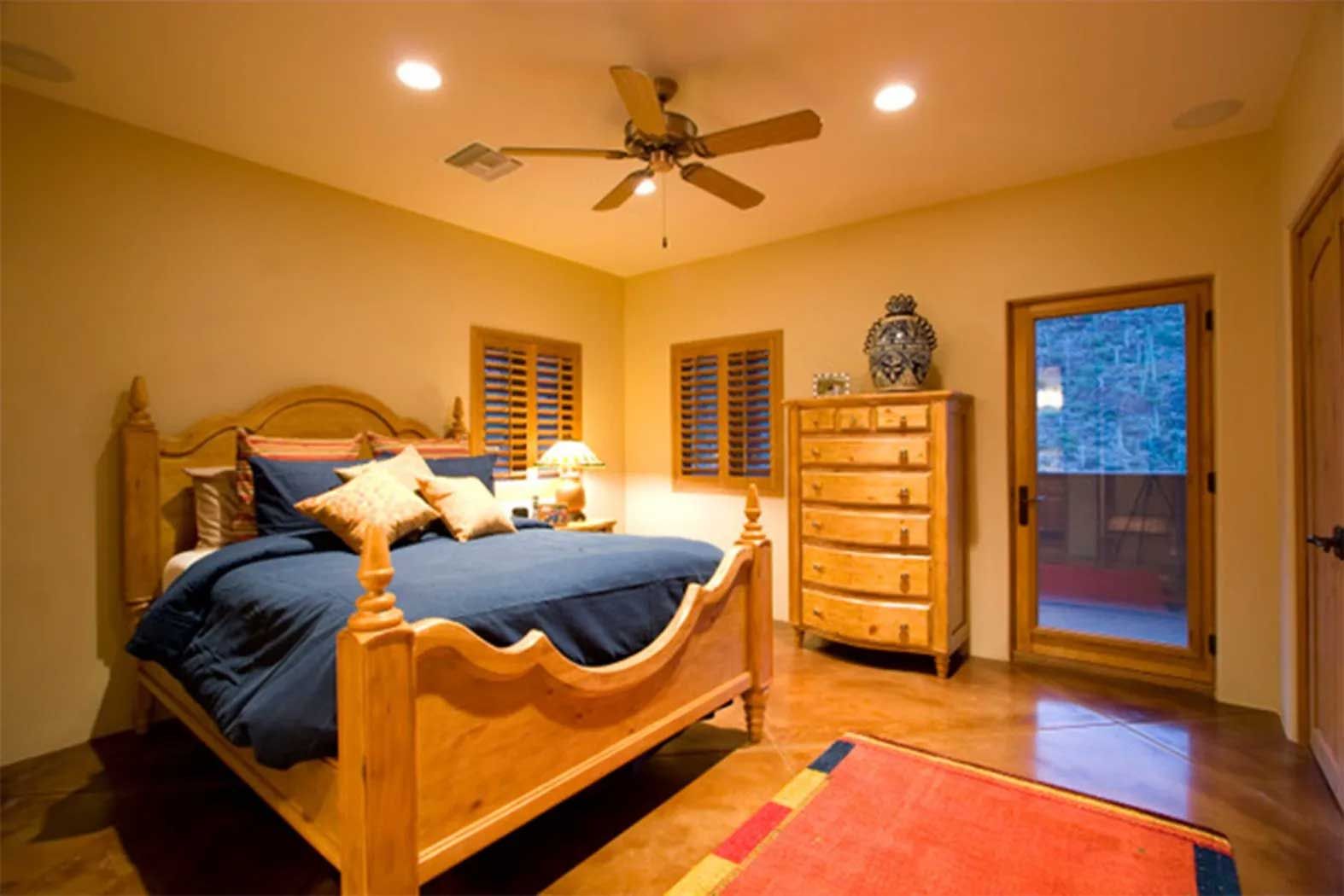A bedroom with a large bed and a ceiling fan