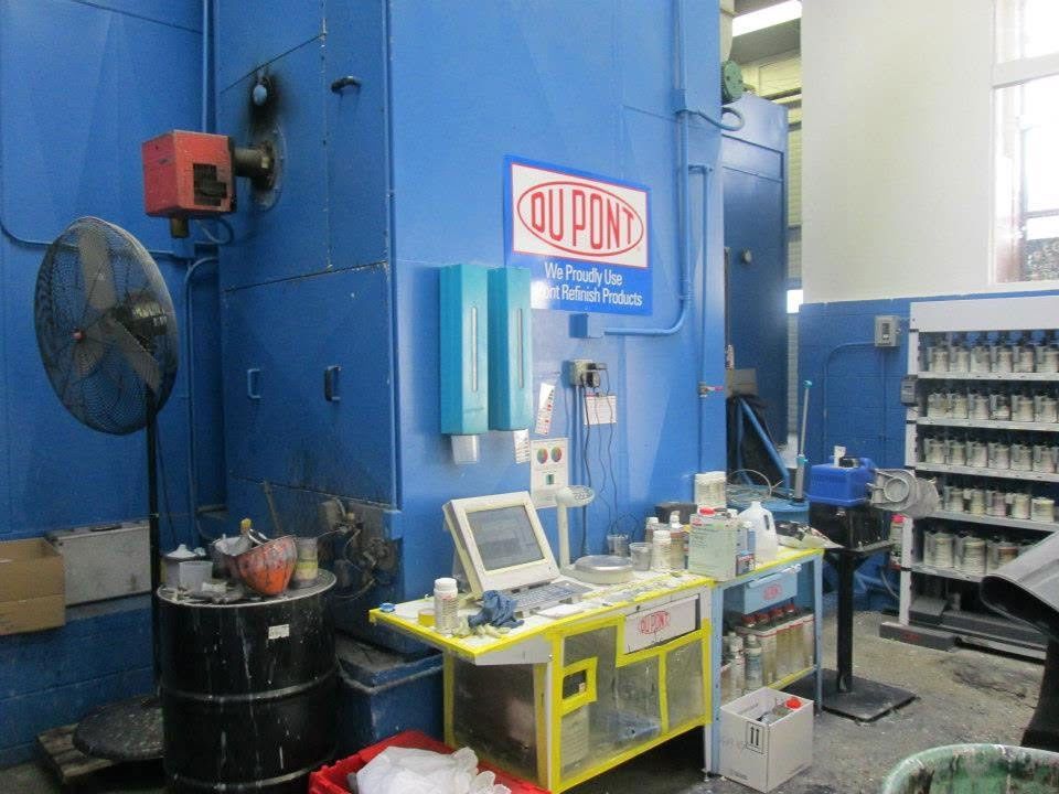 Industrial workshop with blue wall, DuPont sign, yellow workbench, and equipment mounted on the wall